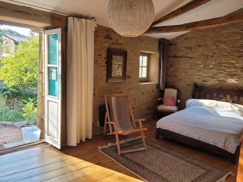 a bedroom with a bed and an open door at Ancienne bergerie de Torteillan in Combes