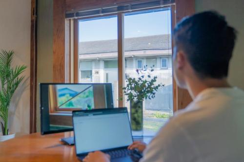 a woman sitting at a desk with a laptop computer at On stay 月見台 in Yokosuka