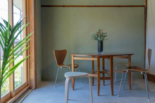 a table and chairs in a room with a plant at On stay 月見台 in Yokosuka
