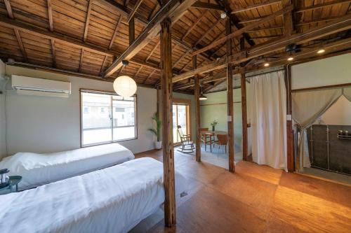 a bedroom with two beds and a dining room with a table at On stay 月見台 in Yokosuka