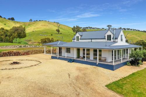 a large white house with a hill in the background at Manandel - Bonnie Doon in Bonnie Doon