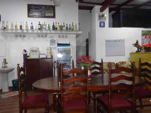 comedor con mesa de madera y sillas en Dutch Bay Beach Cottages, en Trincomalee