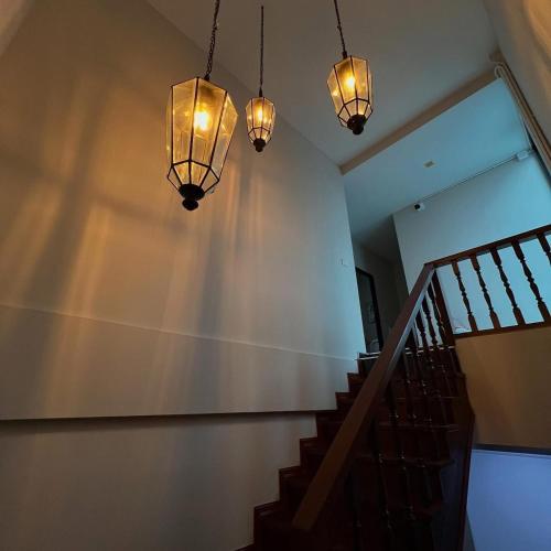 a staircase with lights hanging from a wall at Poshtel 56 in Bangkok