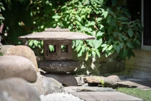 a stone lantern sitting on top of some rocks at Sumida River Temple Villa in Tokyo