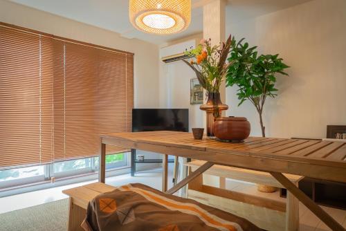 a living room with a wooden table with a vase on it at Sumida River Temple Villa in Tokyo