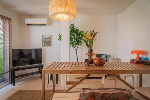a living room with a wooden table and a television at Sumida River Temple Villa in Tokyo