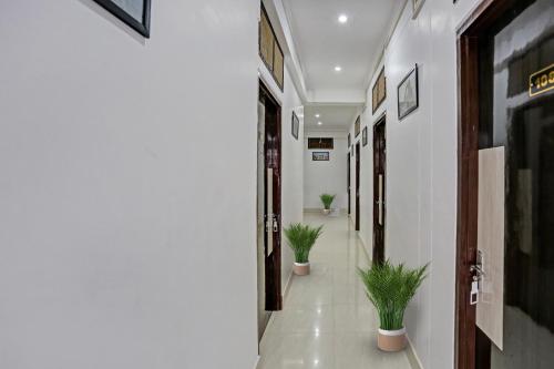 a corridor with potted plants in a hallway at Hotel O Citylight in Colonelganj