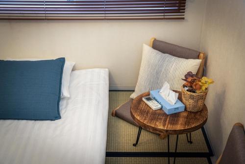 a bedroom with a bed and a table with a phone at Sumida River Temple Villa in Tokyo