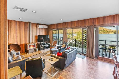 a living room with a couch and a tv andwindows at Bonnie Dawn - Bonnie Doon in Bonnie Doon