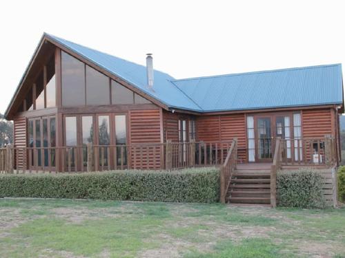 a log home with a blue roof at Mountain Bay Log Home in Goughs Bay