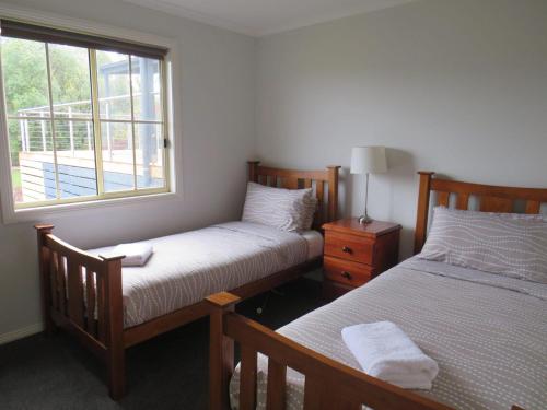 two beds in a room with a window at Bluestones in Merrijig