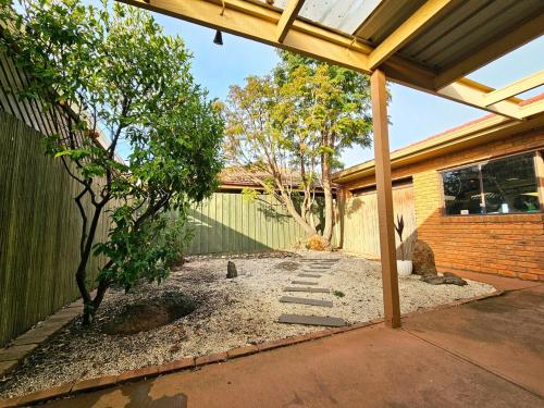 a backyard with a tree and a fence at Peaceful Garden location in Hoppers Crossing in Tarneit