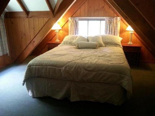 une chambre avec un grand lit avec une fenêtre dans l'établissement Goulburn River Cottage, à Jamieson