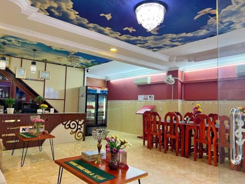 a restaurant with a dining room with a ceiling with clouds at Unique Hotel in Phnom Penh