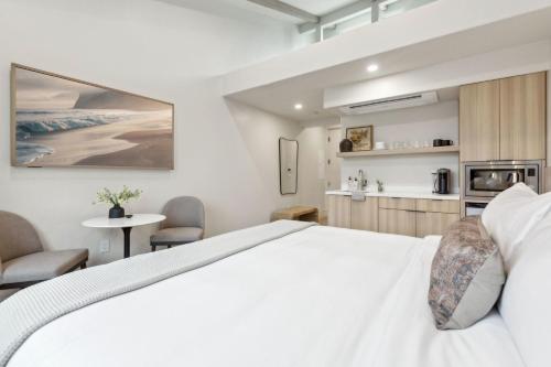 a bedroom with a white bed and a table and chairs at Casa Riviera - Boutique Suites in Downtown Santa Barbara in Santa Barbara