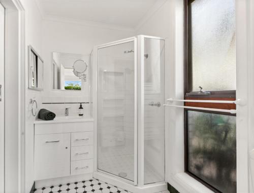 a white bathroom with a shower and a sink at Braemore in Mansfield