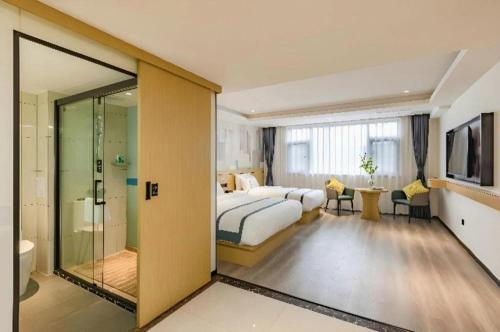 a hotel room with a bed and a bathroom at City Comfort Inn Kunming Dashuying Yejin Hospital Wangdaqiao in Kunming