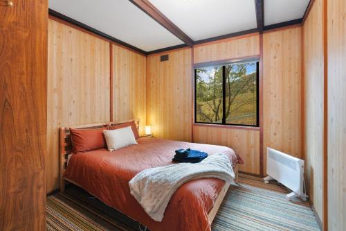 a bedroom with a bed in a room with a window at Milly @ Sawmill in Mount Buller