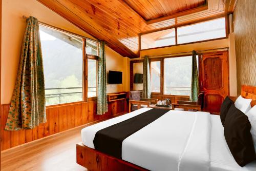 a bedroom with a bed in a room with windows at Hotel O Model Town Road in Manāli
