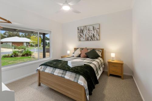 a bedroom with a bed and a window at Timber Mill Cottage in Mansfield