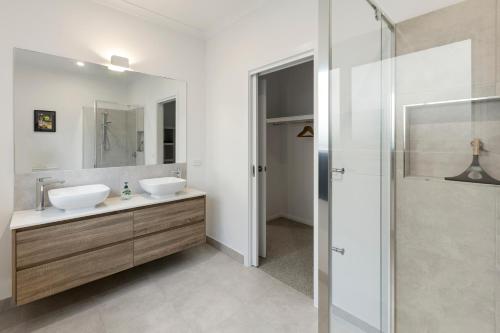 a bathroom with two sinks and a shower at Timber Mill Cottage in Mansfield