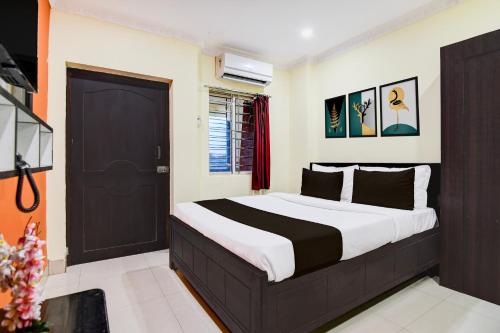a bedroom with a large bed with a black door at Super Collection O Zoological Park Formerly Nandankanan Resort in Bhubaneshwar