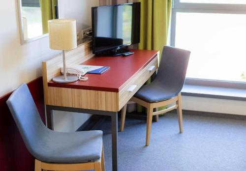 a room with a desk with a computer and two chairs at Aqua-Zdrój in Wałbrzych