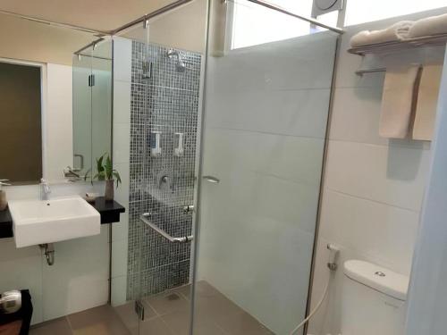 a bathroom with a glass shower and a sink at The Arnawa Hotel in Pangandaran