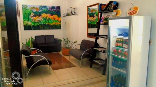 a living room with a refrigerator filled with drinks at Campus Liberdade Flat in Belo Horizonte