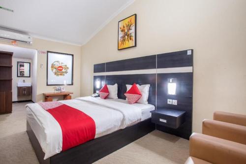 a hotel room with a large bed with red pillows at Capital O 887 Green Hill Hotel And Convention Center in Jember