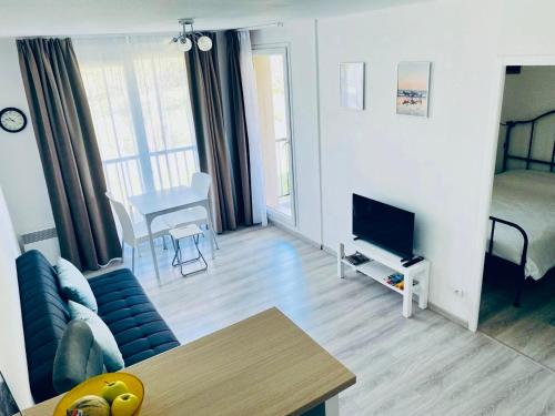 un salon avec un canapé et une télévision dans l'établissement Apartment - Equemauville - Normandie, à Équemauville