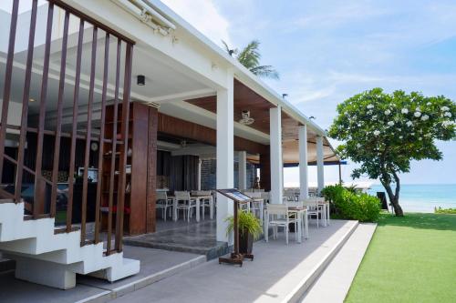 a building with tables and chairs and the ocean at KC Beach Club & Pool Villas in Chaweng