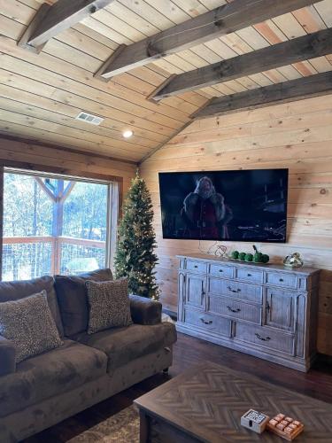 a living room with a couch and a christmas tree at NEWLY BUILT Amazing View Chalet Perfect Location in Gatlinburg