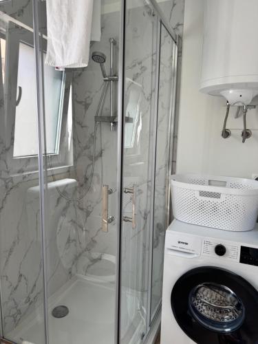 y baño con ducha y lavadora. en Holiday Home Ahil 1, en Pakoštane