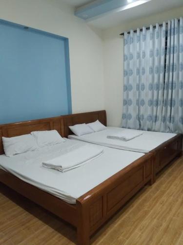 a bedroom with a bed with white sheets and a window at Quyên-homestay in Vung Tau