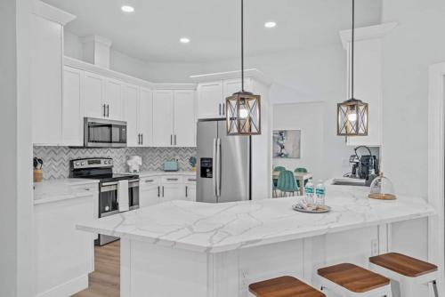 a kitchen with white cabinets and a large white counter top at Chic Stylish Pool House 4 King bed new renovated in Plant City