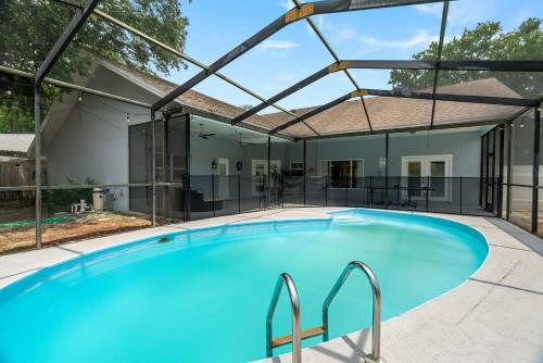 a large swimming pool in a house with an open roof at Chic Stylish Pool House 4 King bed new renovated in Plant City