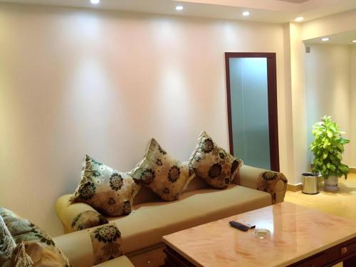 a living room with a couch with pillows on it at Jian Guo Grand Hotel in Vientiane
