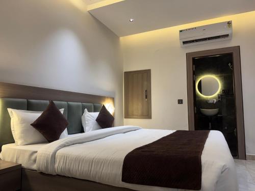 a bedroom with a large bed and a bathroom at C2 Hotel in Mathura
