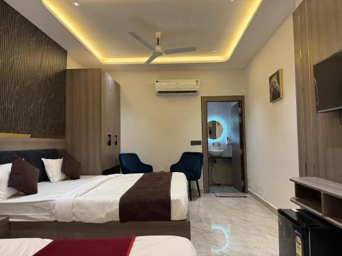 a hotel room with two beds and a bathroom at C2 Hotel in Mathura