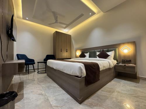 a hotel room with a large bed and a desk at C2 Hotel in Mathura
