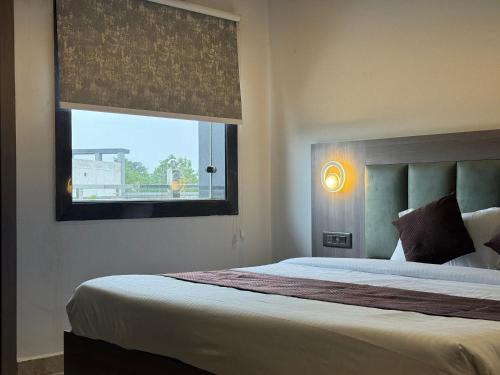 a bedroom with a large bed and a window at C2 Hotel in Mathura