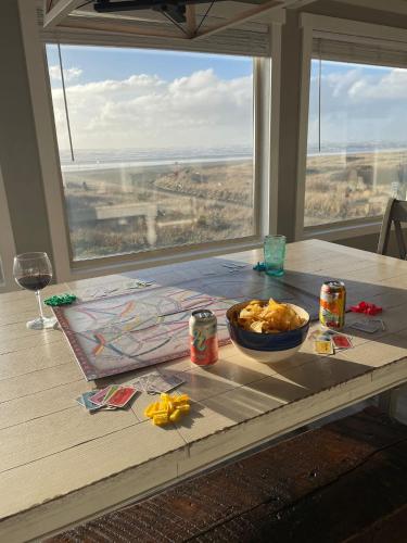 a table with a bowl of food and a glass of wine at Tide Pool Town Home, Entire House, Amazing Views! in Moclips
