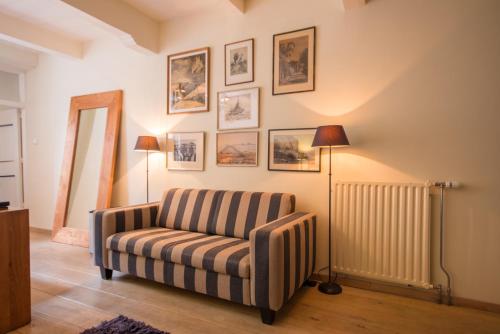 a living room with a striped chair and a lamp at Auberge de Campveerse Toren in Veere