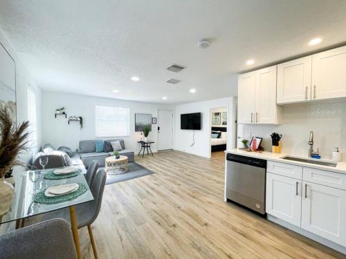a kitchen and living room with a table and a couch at Chic and Cosy Newly renovated Near the Beach in St Petersburg