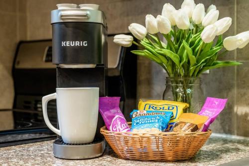 a coffee maker and a basket of food and flowers at Villa Signor in Norwich
