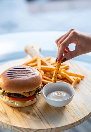 a tray with a hamburger and french fries on a table at La Luna Hotel in Troulos