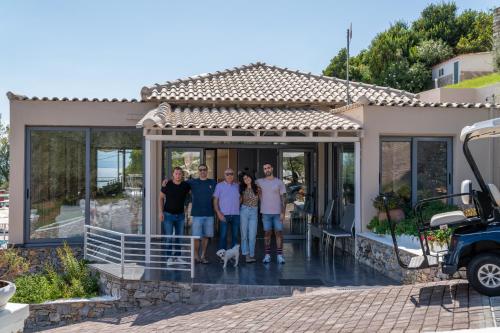 a group of people standing on the front of a house at La Luna Hotel in Troulos