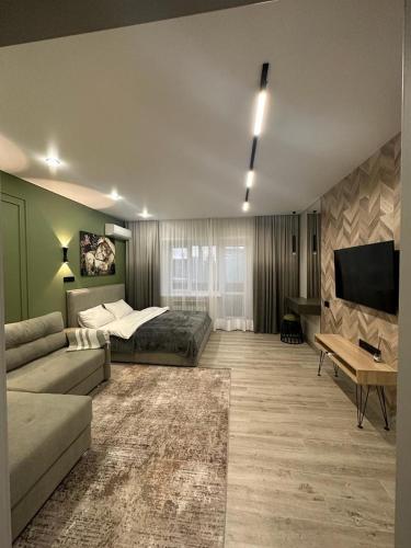 a large living room with a bed and a couch at Современная квартира в центре города in Kostanay