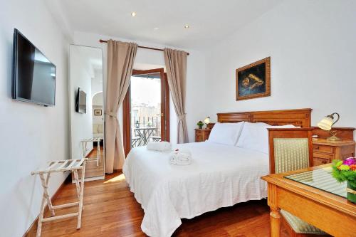 a bedroom with a bed and a table and a television at Terrazze Navona in Rome